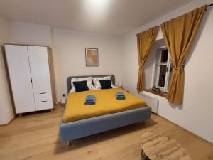 a bedroom with a large bed with a yellow blanket at Vocell in Kutná Hora