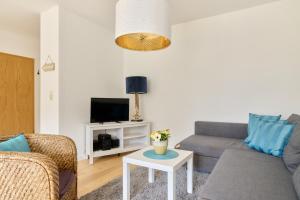 a living room with a couch and a tv at Ferienwohnung Sonnendeck Moba-Travel in Priwall