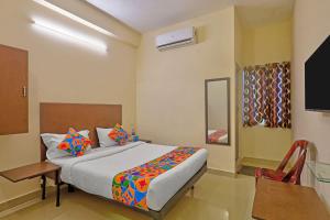 a bedroom with a bed and a table and a television at Via KR in Chennai