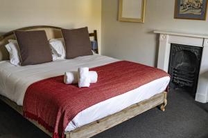 a bed with two stuffed animals sitting on it at The Old Cannon Brewery in Bury Saint Edmunds