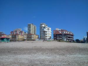 un groupe de bâtiments sur une plage avec des condos dans l'établissement Apartamento Libra 6, à Villa Gesell