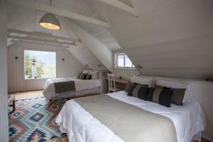 a attic bedroom with two beds and a window at Mareas Ralun Lodge in Ralún