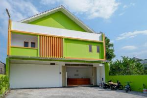 a green and white house with a garage at RedDoorz @ Jalan Wonosari KM.9 in Yogyakarta +31 photos