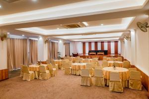 a banquet hall with tables and chairs and a piano at Dhulikhel Lodge Resort in Dhulikhel