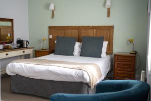 a bedroom with a large bed and a blue chair at The Old Cannon Brewery in Bury Saint Edmunds +11 photos