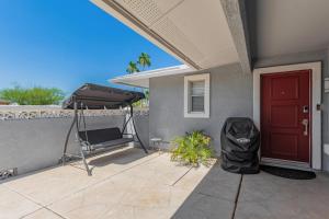 a porch with a red door and a chair at Naturally Modest & Quiet in Sun City West