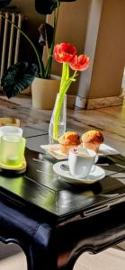 ein Tisch mit Cupcakes und einer Vase mit Blumen darauf in der Unterkunft Belrom Hotel in Sint-Truiden + 48 Fotos