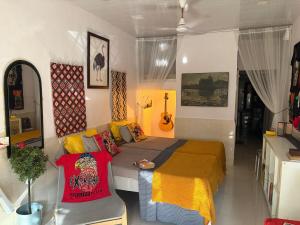 a bedroom with a bed and a guitar on the wall at Sun Bloom in Mumbai