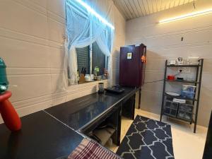 a kitchen with a table and a refrigerator and a window at Sun Bloom in Mumbai