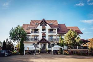 a large white building with a red roof at Pension Elegance in Gura Humorului