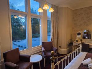 a room with two chairs and a large window at Oaklands Hall Hotel Grimsby in Laceby