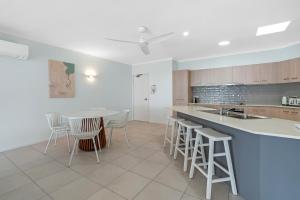 a kitchen with a counter and a table and chairs at Relax at Trinity in Trinity Beach