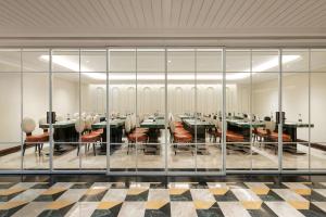 a conference room with glass walls and tables and chairs at Heritage Ham Long Hotel and Spa in Hanoi +151 photos