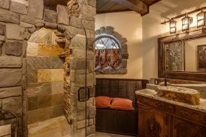 a bathroom with a stone wall at Storybook Riverside Inn in Leavenworth