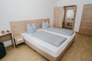 a bedroom with a large white bed and a mirror at Cityhotel Donauwörth in Donauwörth