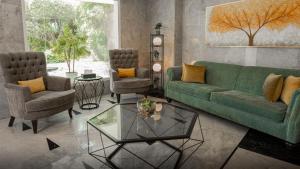 a living room with a green couch and two chairs at La Vida Suite in Beirut