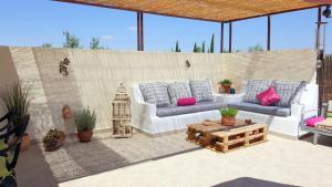 een patio met banken, een tafel en potplanten bij La casa de Lu in Archidona