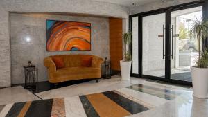 a living room with a couch and a painting on the wall at La Vida Suite in Beirut