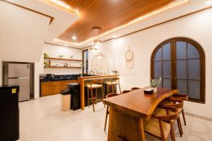 a kitchen with a wooden table and some chairs at Green Mutiara Jimbaran in Jimbaran