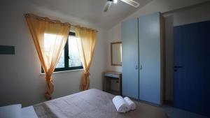 a bedroom with a bed and a window at Charme by the Sea, Sant'Andrea in SantʼAndrea Apostolo dello Ionio