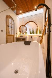 a bath tub in a bathroom with a sink at Green Mutiara Jimbaran in Jimbaran +43 photos