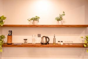 a wooden shelf with plants and glasses on it at Green Mutiara Jimbaran in Jimbaran