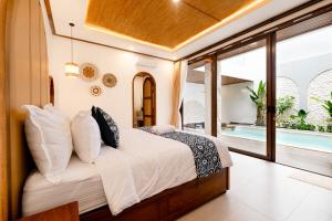 a bedroom with a bed and a swimming pool at Green Mutiara Jimbaran in Jimbaran
