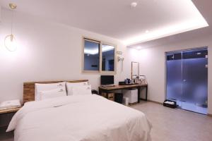 a bedroom with a bed and a desk and a window at Novahotel in Samgong