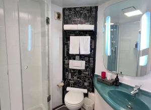 a bathroom with a sink and a toilet and a mirror at Ibis Tianjin Development Zone TEDA Third Avenue in Binhai