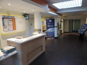 een lobby met een receptie in een gebouw bij ibis budget Lille Wasquehal in Wasquehal