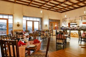 a dining room with tables and chairs and windows at The Old Village Hotel & Resort in Wadi Musa