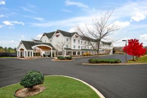 a large white house with a tree in the driveway at Hampton Inn Rutland/Killington in Rutland