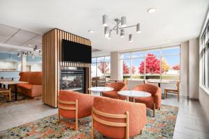 a lobby with a fireplace and tables and chairs at Hampton Inn Rutland/Killington in Rutland