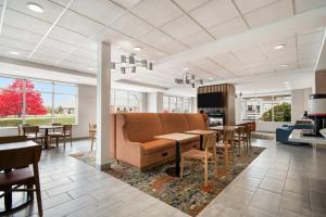 a waiting room with a couch and tables and chairs at Hampton Inn Rutland/Killington in Rutland