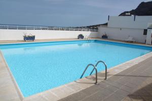 a large swimming pool with blue water at Apartamentos Nautilus in Bajamar