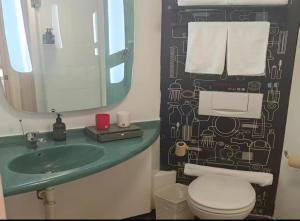 a bathroom with a sink and a toilet and a mirror at Ibis Tianjin Development Zone TEDA Third Avenue in Binhai