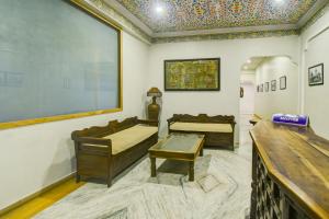 a room with two beds and a large painting on the wall at Townhouse Chandpole Metro Station Formerly Hotel Raghuraj Palace in Jaipur