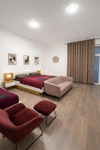 a bedroom with a bed and a couch and a chair at City Rooms Koblenz Hbf in Koblenz