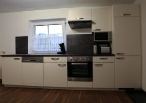 una cocina con electrodomésticos de acero inoxidable y una ventana en Ferienwohnung Köchl, en Münster