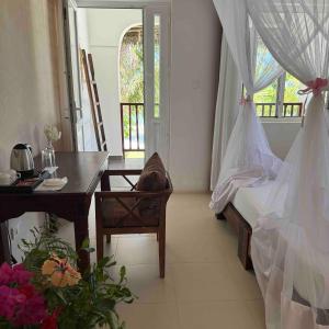 a bedroom with a desk and a bed and a table at MANOLO Beach Resort in Uroa