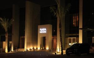 a building with palm trees in front of it at night at Rafa - Al Nuzhah in Riyadh