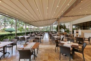 a restaurant with tables and chairs and windows at Juju Premier Palace Hotel-Ultra All Inclusive in Beldibi