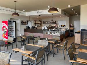 a restaurant with tables and chairs and a bar at Glamping Sistiani in Lido di Spina