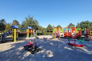 a playground with colorful play equipment in a park at Glamping Sistiani in Lido di Spina