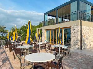 a group of tables and chairs with yellow umbrellas at Glamping Sistiani in Lido di Spina