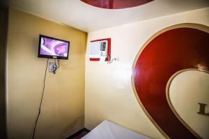 a room with a mirror and a tv on the wall at Astrotel Novaliches in Manila