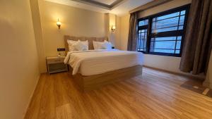 a bedroom with a large bed and a large window at Juniper Mountain Resort in Lachen