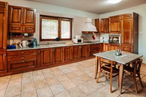 a large kitchen with wooden cabinets and a table at Lac Sub Soare in Vărbila