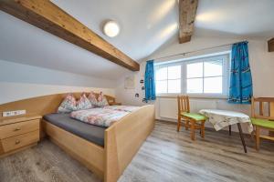 a bedroom with a bed and a desk and a window at Apartment Wenger Leogang in Leogang