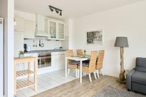 a kitchen and dining room with a table and chairs at Ferienwohnung Bootsteg Moba-Travel in Priwall